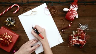 young-woman-sitting-at-wooden-table-writing-letter-to-santa-at-christmas-holiday-concept-of-new-year-magic-dream-and-tradition_rhd33ygge_thumbnail-small01