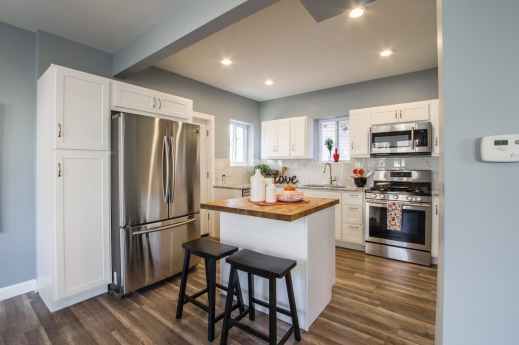 two black wooden bar stools near table and french door refrigerator