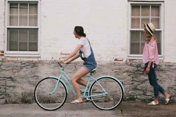 woman riding on teal cruiser bike near woman wearing pink long sleeved shirt