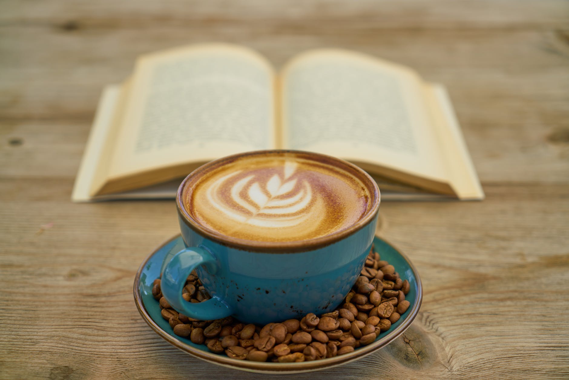blue ceramic teacup with saucer beside book