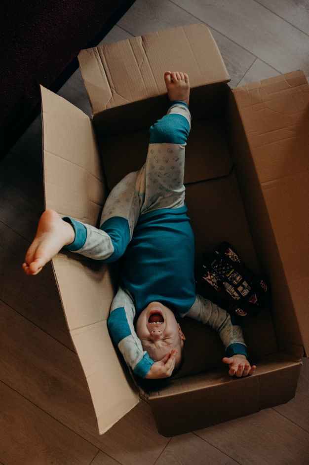 little boy crying inside a box