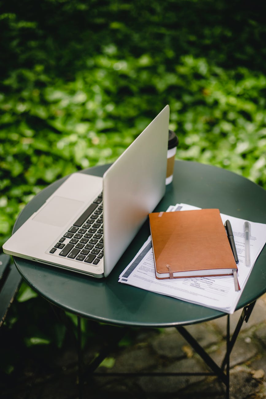 laptop and documents on table in garden